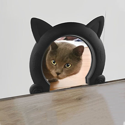 Chat gris chartreux utilisant une chatière moderne noire installée dans une porte blanche