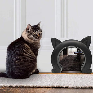  Chat tigré assis à côté d'une chatière design noire en forme de tête de chat.