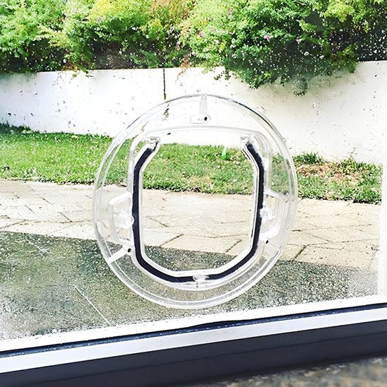 Chatière ronde transparente avec joint isolant installée sur fenêtre double vitrage