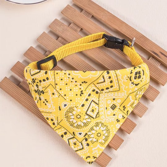 Collier chat bandana jaune motifs paisley ajustable sur surface bois