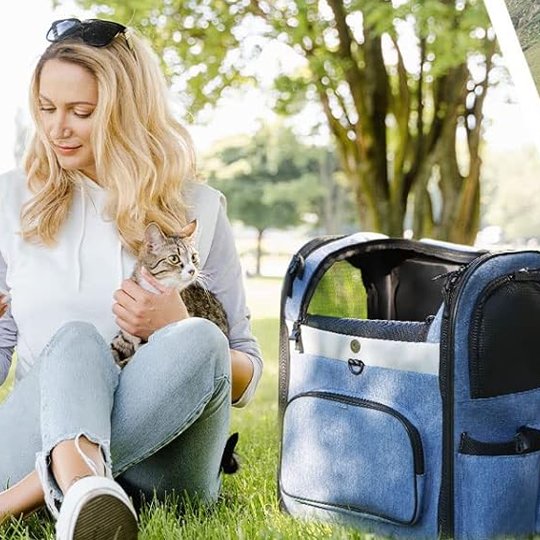 Femme assise dans un parc avec son chat à côté d'un sac de transport pour chat bleu