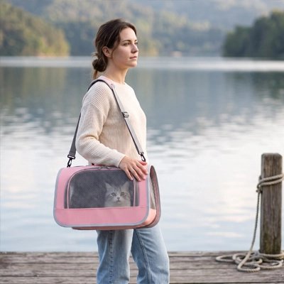 Femme portant un sac de transport pour chat rose sur un ponton au bord de l'eau