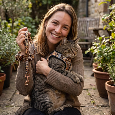 Harnais chat léopard avec laisse assortie, femme tenant son chat tigré dans un jardin