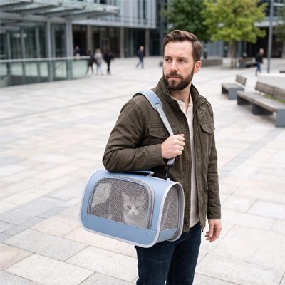 Homme portant un sac de transport pour chat bleu clair sur une place urbaine