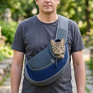 Homme portant un sac de transport pour chat bleu en bandoulière avec un chat tigré qui passe la tête