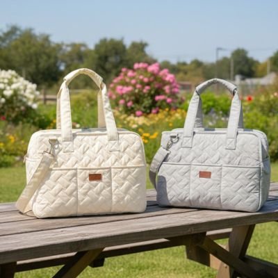 Sac de transport chat beige et gris posés sur une table en bois dans un jardin fleuri