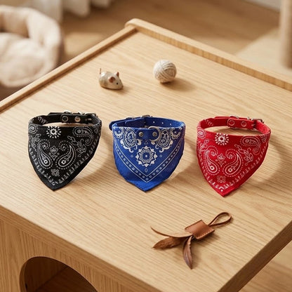 Trois bandanas pour chat noir, bleu et rouge à motifs cachemire avec collier à boucle, posés sur une table en bois