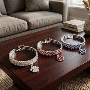  Trois colliers chat strass cristal avec pendentif patte posés sur table basse