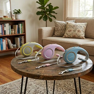 Trois laisses rétractables chat coloris pastel sur table
